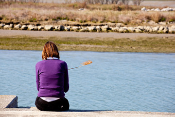 Donna seduta in riva al fiume