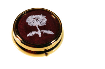 Gilded pillbox with lace flower, isolated on white