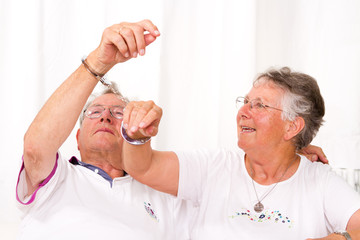 älteres Ehepaar, mit Handschellen aneinander gebunden