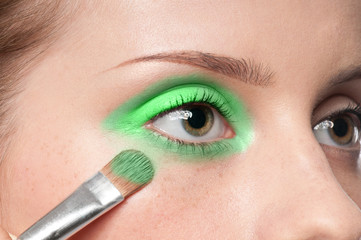 Woman applying cosmetic paint brush on eye zone