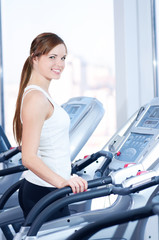 Fototapeta premium Young woman at the run at gym