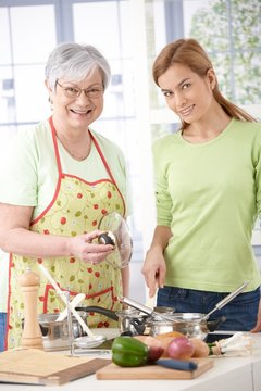 Mother and daughter in kitchen smiling