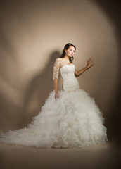Naklejka premium The beautiful young woman posing in a wedding dress