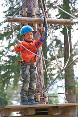 Kid climbing trees in Dolomites, Italy.