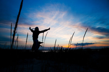 woman jumping at the sunset
