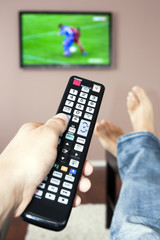 Men with the remote control, front of the television.