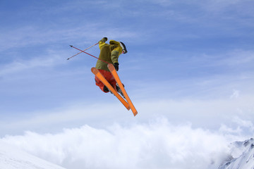 a skier jumping high through a blue sky
