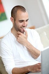 Fototapeta na wymiar Closeup of handsome man websurfing on laptop computer