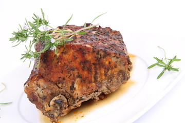 Roast pork decorated with rosemary blooming twigs