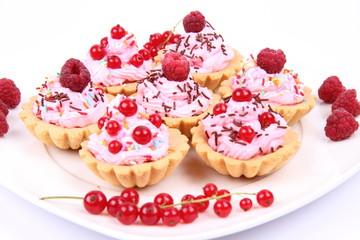 Tartlets with whipped cream, fruits and sprinkles