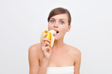 beautiful woman in white biting banana.