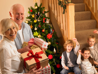 Obraz na płótnie Canvas Starszy para z wnukami na Boże Narodzenie