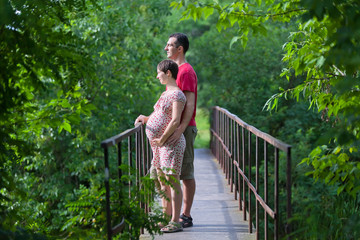 Husband with his pregnant wife on the bridge