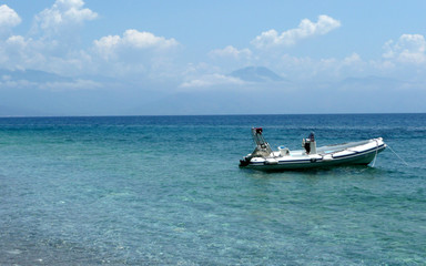 Fototapeta na wymiar Inflatable boat anchored on the pebble beach