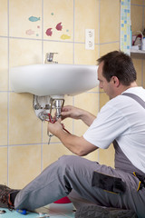 Klemptner repariert ein verstopftes Abflußrohr im Badezimmer.