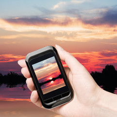 mobile phone removes the beautiful sunset