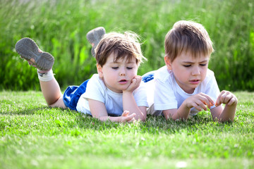siblings lying on grass