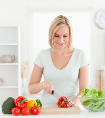Cute woman cutting vegetables