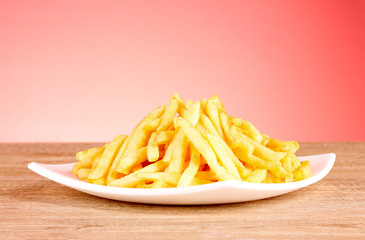 French fries and a plate on a red background