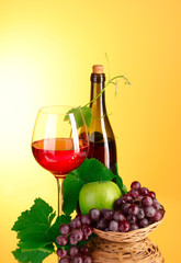 Red wine and fruits on yellow background