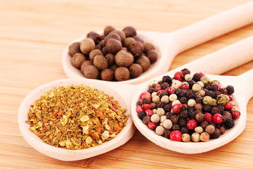 Spices in spoons on wooden table