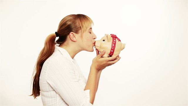 Woman kissing a piggy bank