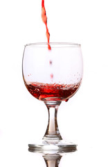 Red wine pouring down into a wine glass