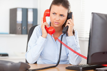 Businesswoman telephoning with two devices
