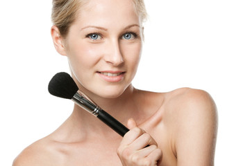 Youngfemale applying mineral powder with make-up brush