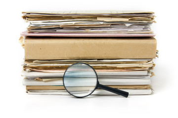 Magnifying lens  on the background of the stack of old files