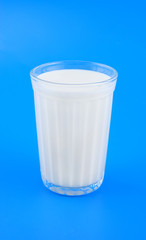 Glass of milk on blue background