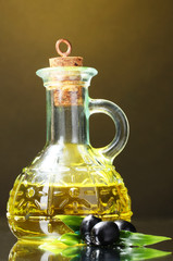 olive oil and olives on yellow background
