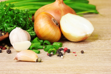 spices, onion, garlic and parsley on a wooden background