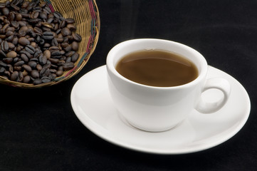 Taza de Café aislado en fondo  negro con frijoles