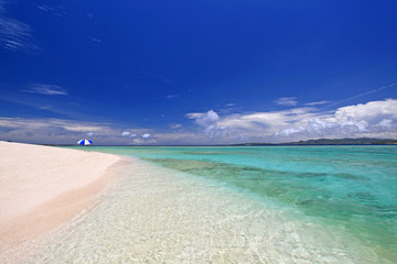 水納島の澄んだサンゴ礁の海と紺碧の空