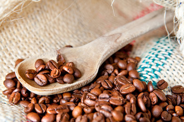 cucchiaio in legno con chicchi di caffè tostati