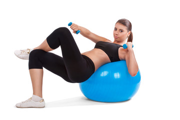 Fototapeta premium strong girl lifting dumbbells on fitball