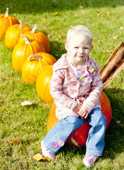 little girl with pumpkins