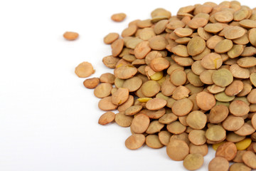 Pile of green lentils from low perspective isolated on white.