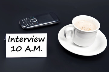 Interview message on desk with coffee