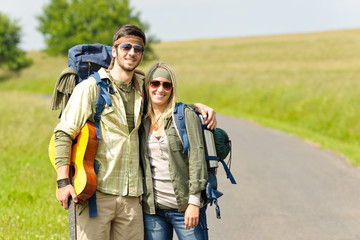 Obraz na płótnie Canvas Hiking young couple backpack tramping asphalt road