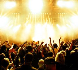 concert crowd in front of bright yellow stage lights