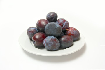 Plums on white plate