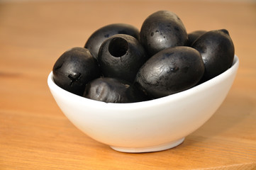 Big black olives in a small white bowl.  