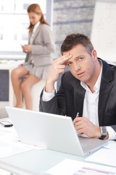 Middle-aged businessman sitting troubled at desk