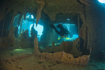 Divers exploring a large shipwreck