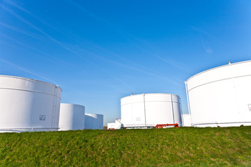 white tanks in tank farm with blue sky