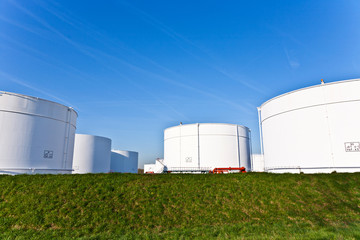 white tanks in tank farm with blue sky