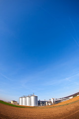 silver silos with blue sky