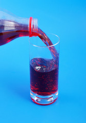 Cherry juice pouring isolated on blue background